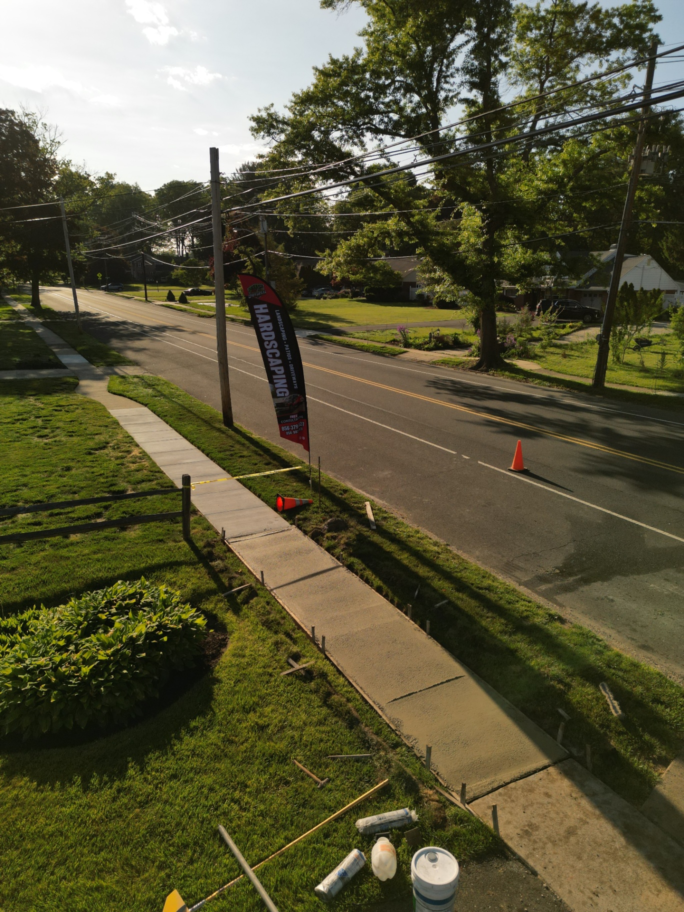 Fresh poured concrete sidewalk with Universal Hardscaping flag in Moorestown New Jersey