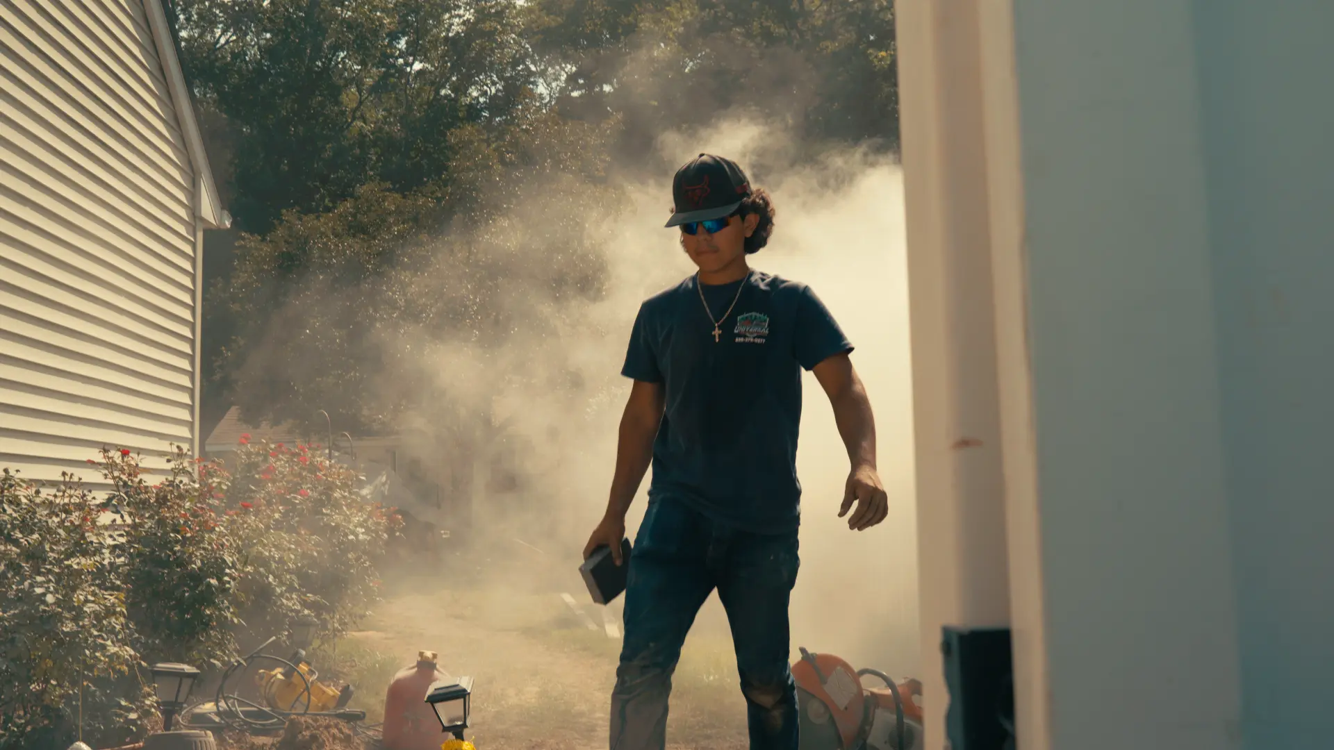 Crew member walking through saw dust after cutting pavers in a side yard