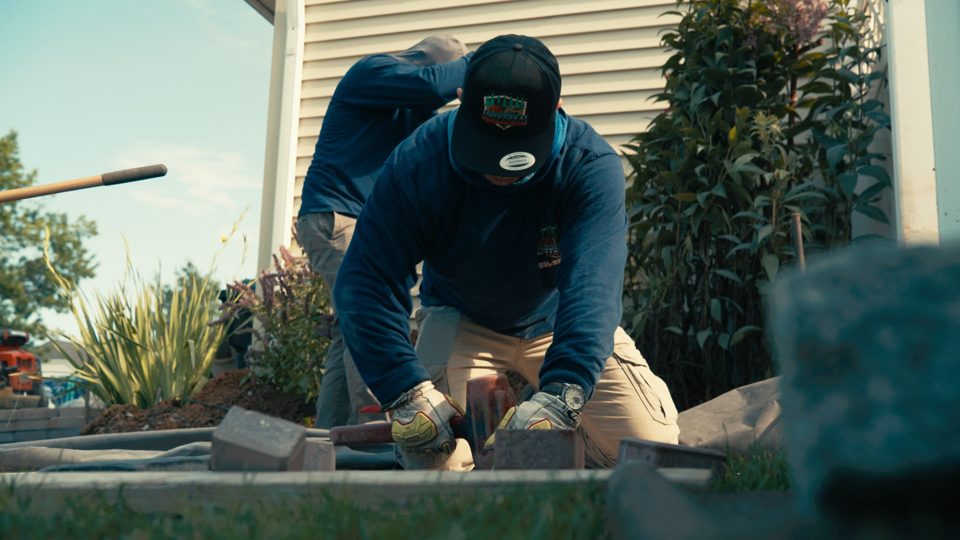 Close-up of a crew member setting wall block with a rubber mallet